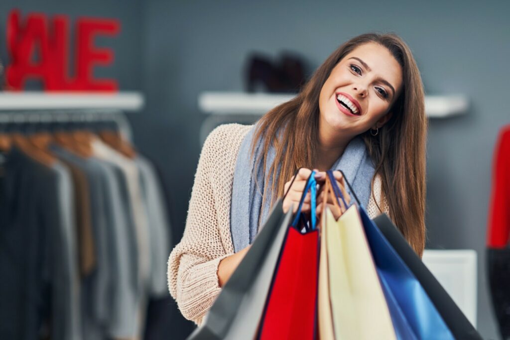 Adult women shopping for clothes in boutique in autumn